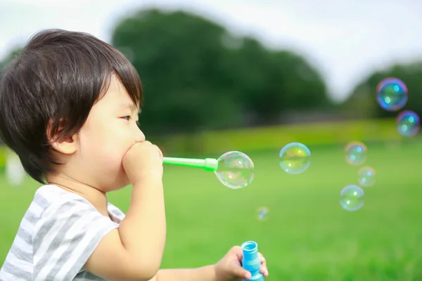 Asian Little Boy Blowing Soap Bubbles Park Outdoors Royalty Free Stock Photos