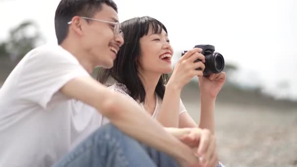 Feliz Joven Asiático Pareja Sentado Playa Fotografiando Con Cámara — Vídeo de stock