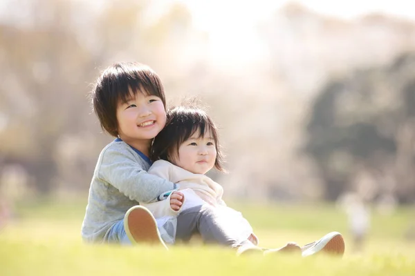 Pequeno Menino Japonês Sua Irmã Sentado Grama Belo Parque Verão — Fotografia de Stock