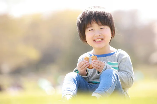 在夏季公园吃饭的快乐日本男孩的画像 — 图库照片