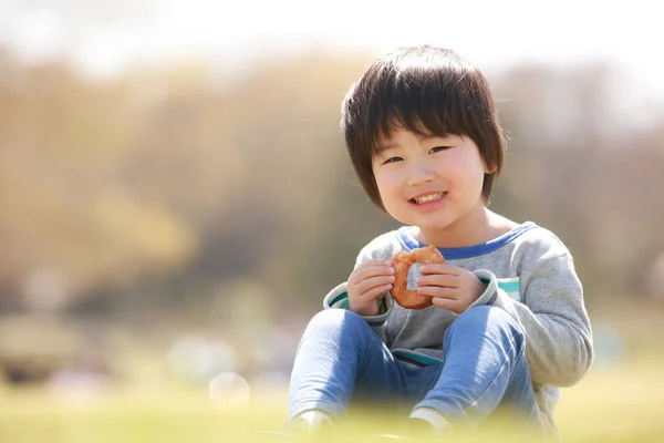 Πορτρέτο Του Ευτυχισμένου Γιαπωνέζου Αγοριού Που Τρώει Στο Καλοκαιρινό Πάρκο — Φωτογραφία Αρχείου