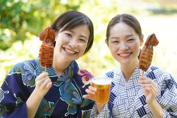 着物姿の美しい日本人女性がストリートフードを楽しむ — ストック写真
