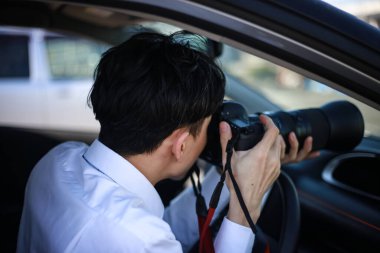 Arabada fotoğraf çeken bir adam var.