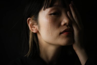 Koyu arkaplanda ağlayan Japon kadının portresi 