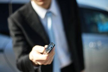 Görüşme için ses kaydedici kullanan takım elbiseli bir Asyalı.