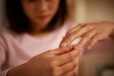 Genç Asyalı kadın yüzüğü çıkarıp boşanmayı düşünüyor.