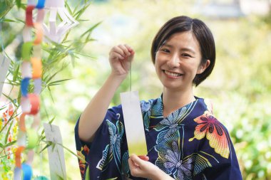 Tanabata festivali için Tanzaku 'yla ağaç süsleyen güzel Japon kadınları.