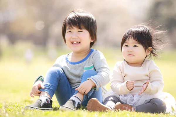 Pequeno Menino Japonês Sua Irmã Sentado Grama Belo Parque Verão — Fotografia de Stock