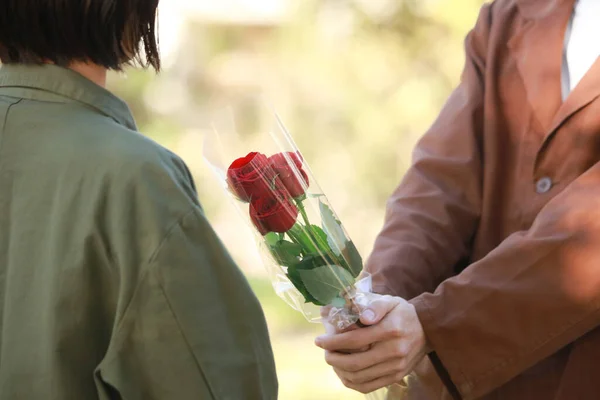 Νεαρός Ασιάτης Που Δίνει Τριαντάφυλλα Στη Γυναίκα — Φωτογραφία Αρχείου
