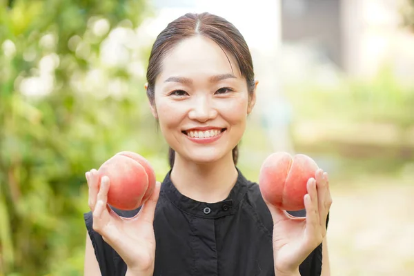 Porträtt Lycklig Japansk Kvinna Som Håller Färska Persikor Händerna — Stockfoto