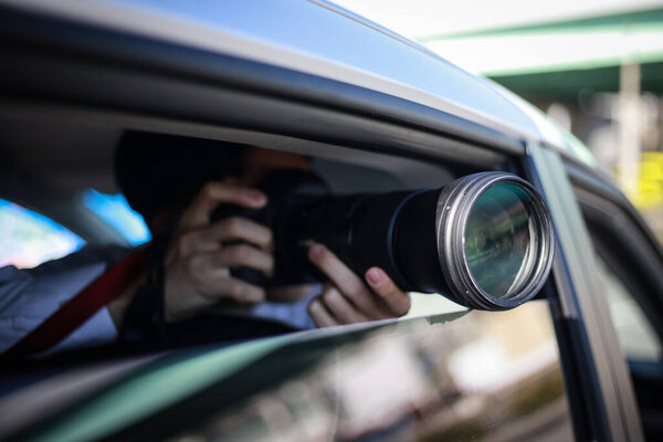 young man  in the car with camera, paparazzi