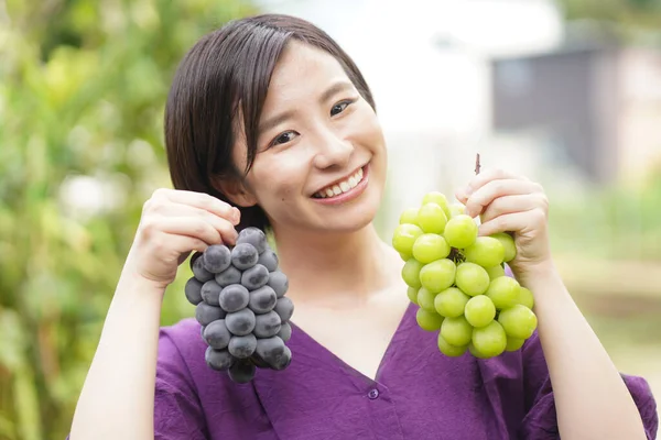 Porträtt Lycklig Japansk Kvinna Som Håller Färska Druvor Händerna — Stockfoto