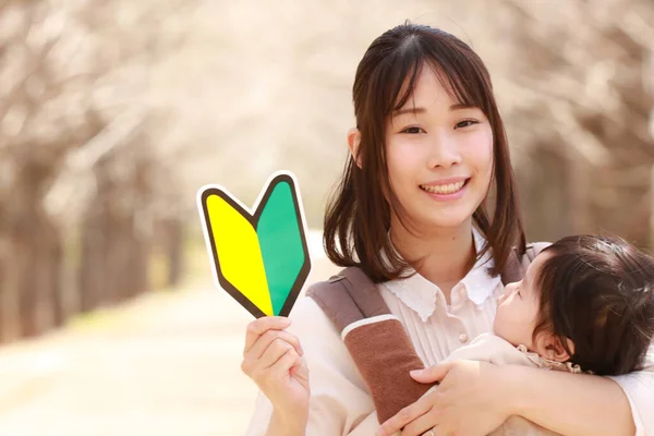 Glückliche Mutter Trägt Baby Und Hält Gelb Grünes Schild Park — Stockfoto