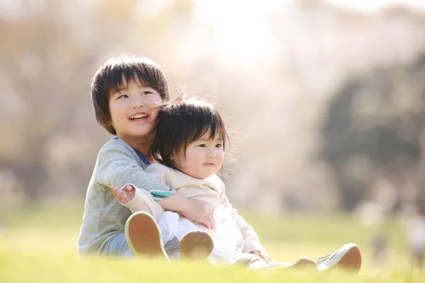 Pequeno Menino Japonês Sua Irmã Sentado Grama Belo Parque Verão — Fotografia de Stock