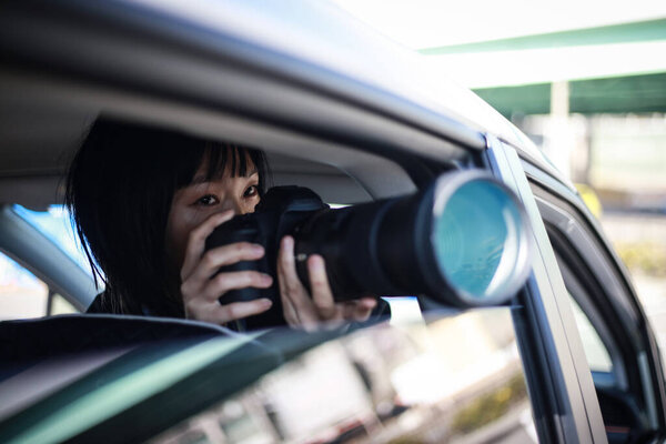   beautiful asian young woman  in the car with camera 