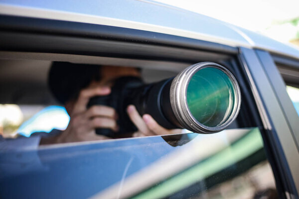 selective focus shot of young man sitting in car with a camera