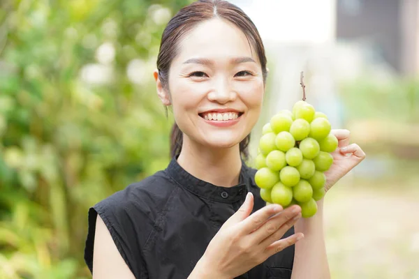 Πορτρέτο Της Ευτυχισμένης Γιαπωνέζα Κρατώντας Φρέσκα Σταφύλια Στα Χέρια — Φωτογραφία Αρχείου