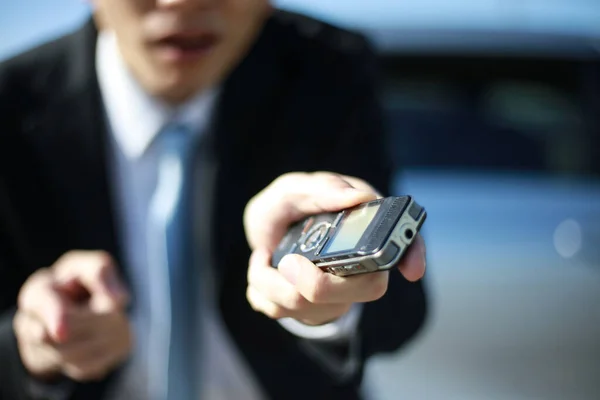 Asian man in suit using voice recorder for interview