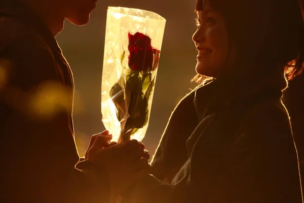 男性から花束を受け取った若いアジア人女性は — ストック写真