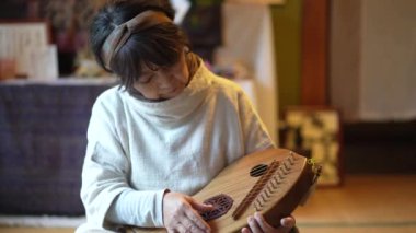 Geleneksel Japon müzik enstrümanı koto çalmak için kadın alıştırması