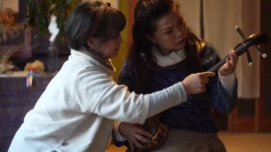 Kadınlar geleneksel Japon müzik enstrümanı Sanshin 'de çalmak için pratik yapıyorlar.