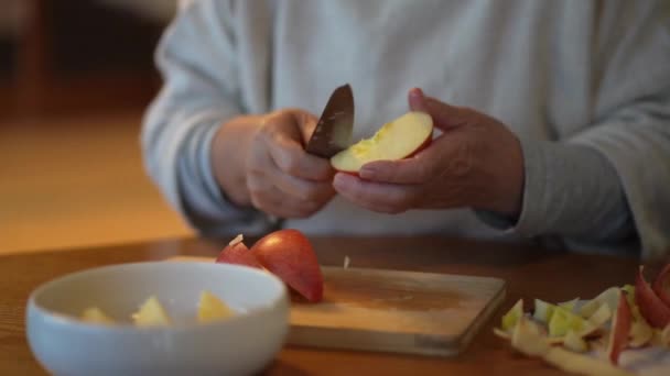 上級女性のクローズアップビューナイフで赤いリンゴの皮 — ストック動画