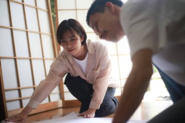 Genç Japon çift Shoji kapıları kuruyor.