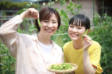 İki Asyalı kızın yaz kazancında eğlenirken portresi.