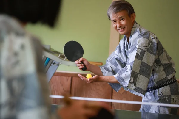 アジア系シニア夫婦が着物で卓球をする — ストック写真