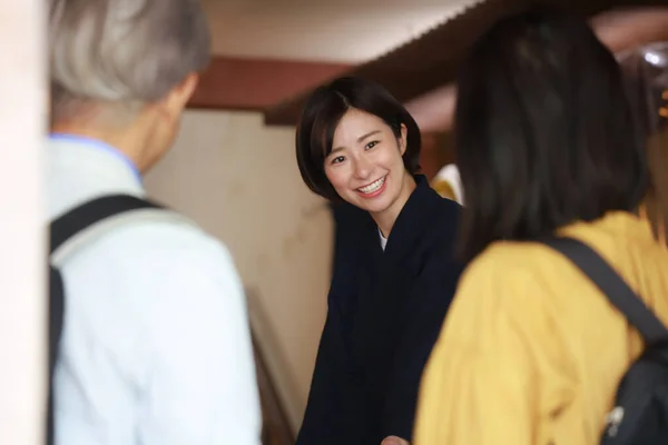 Lächelnde Japanische Rezeptionistin Zeigt Hotelzimmer Für Senioren Paar — Stockfoto
