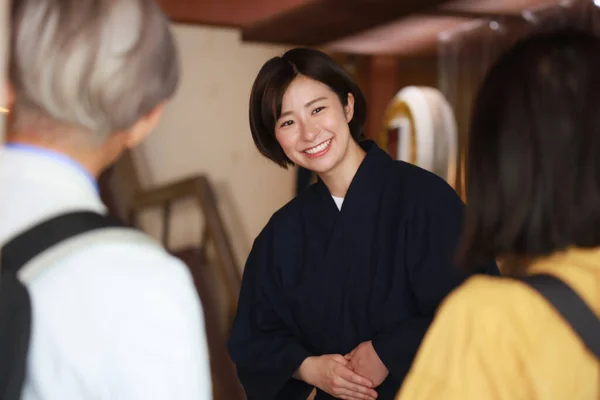 Lächelnde Japanische Rezeptionistin Zeigt Hotelzimmer Für Senioren Paar — Stockfoto