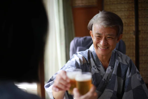 先輩のアジア人男性が妻とビールを飲み — ストック写真