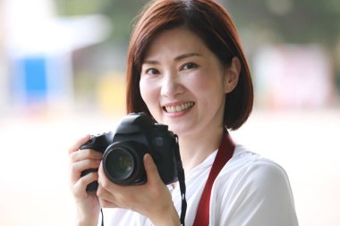  Güzel Asyalı genç bayan fotoğrafçı açık havada