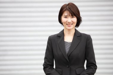 Kameraya gülümseyen güzel Asyalı iş kadınının portresi.