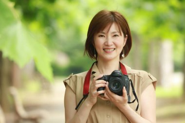 Güzel bir Asyalı genç kadının portresi. Fotoğrafçı, fotoğraf çekiyor.