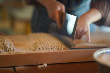 Karabuğday eriştesi hamuru kesen adama yaklaş.