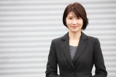 Kameraya gülümseyen güzel Asyalı iş kadınının portresi.