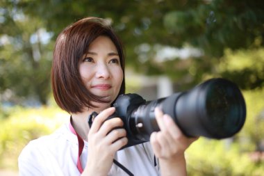  Güzel Asyalı genç bayan fotoğrafçı açık havada