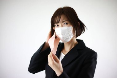 Stüdyoda yüz maskeli genç Asyalı iş kadını 