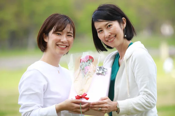 Zwei Asiatische Frauen Mit Geschenk Und Blume — Stockfoto