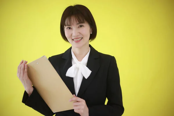 黄色に隔離されたフォルダを持つアジアのビジネス女性 — ストック写真
