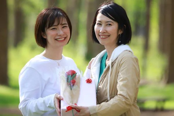 現在と花を持つ2人のアジア系女性 — ストック写真