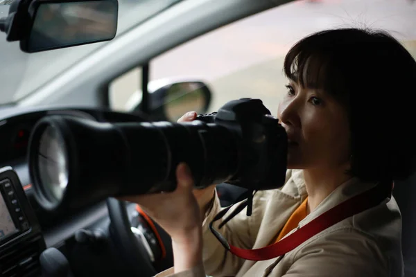 カメラを持った車の中で美しいアジア系の若い女性が — ストック写真
