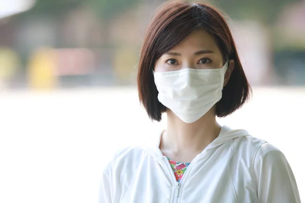 公園のフェイスマスクの若い美しいアジアの女性 — ストック写真