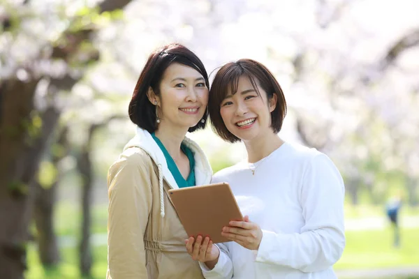 Dos Mujeres Asiáticas Sosteniendo Tableta —  Fotos de Stock