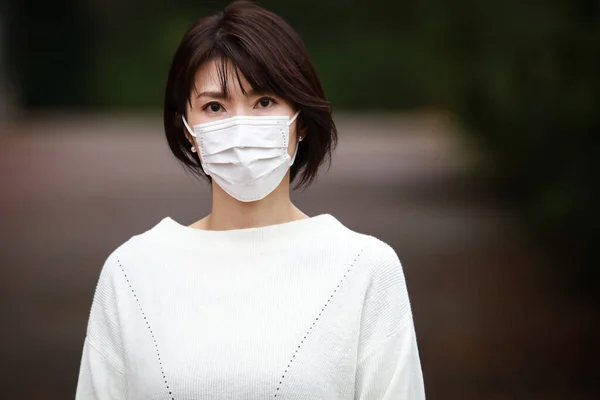 若い美しいアジアの女性は屋外で顔マスクを身に着けて — ストック写真