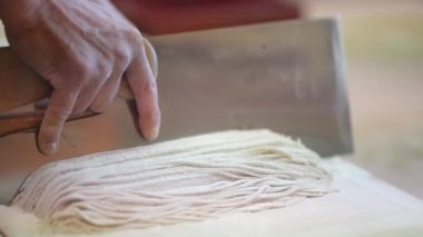 Karabuğday eriştesi hamuru kesen adama yaklaş.