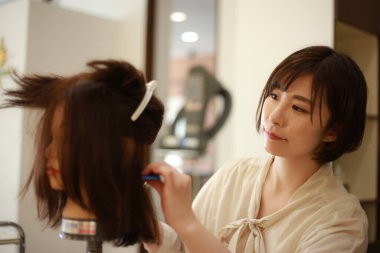 Kuaför kuaförde saç kesmeyi öğreniyor. 