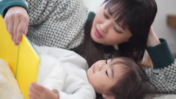 Mor Och Dotter Ligger Sängen Och Läser Bok — Stockvideo