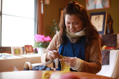 Örgü ören bir kadın resmi 